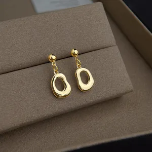 Detailansicht minimalistischer goldener Hängeohrringe im schicken und eleganten Nischendesign.
