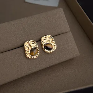 Vergoldete unregelmässige Ohrstecker mit braunem Stein für modischen Damenschmuck.