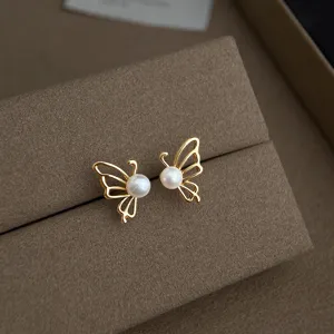 Exquisites Detailfoto von minimalistischen goldenen Schmetterling Perlen Ohrsteckern.