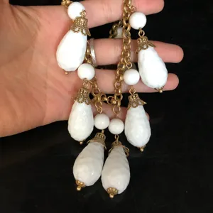 Detailansicht der Vintage-Palast-Stil weißen Glas-Tropfen-Quasten-Kette, eleganter Retro-Schmuck.