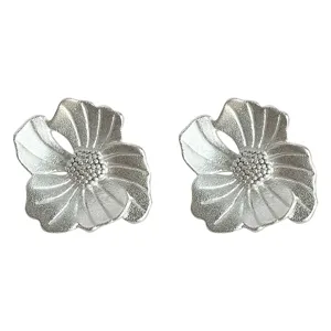 Detailed close-up of textured silver flower stud earrings, matte sandblasted finish, elegant design.
