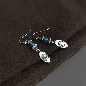 Vintage retro style silver hook earrings with blue beads and spiral sun pendant detail view.