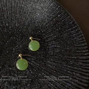 Mint green geometric round earrings detail shot, chic French style minimalist jewelry piece.