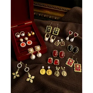 Detailed shot of vintage French style retro geometric earrings set with pearls and red stones.