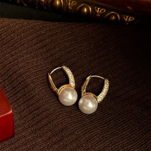 Close-up view of French vintage style geometric gold pearl earrings with sparkling pavé cubic zirconia.
