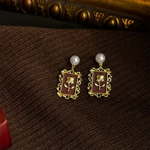 Detail shot of vintage French style Ankara red retro rose frame earrings with pearl drop.
