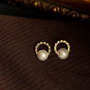 Detailed shot of French vintage retro geometric pearl earrings with elegant gold twist hoop.