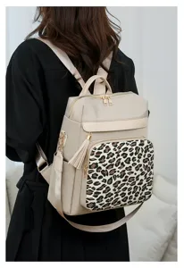 Detailansicht des modischen Damen-Rucksacks mit Leopardenmuster und goldenen Reißverschlüssen.