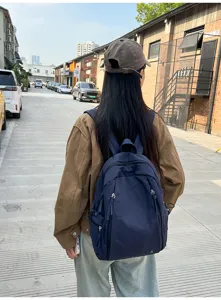 Outdoor lifestyle detail view showcasing the casual nylon backpack worn by a student on street.