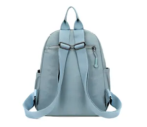 Vue détaillée des bretelles de sac à dos bleu clair et de la poche zippée pratique.