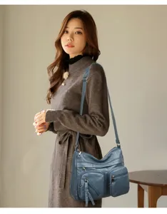 Close-up scene showcasing the elegant blue multi-pocket soft leather shoulder crossbody bag.