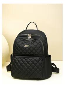 Gros plan détaillé du sac à dos matelassé noir avec fermetures éclair dorées élégantes.
