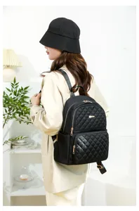 Detail de sac à dos matelassé noir pour femme avec tissu imperméable et fermetures éclair robustes.
