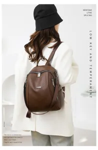 Backpack detail view showing premium brown leather texture, secure zipper and hardware.