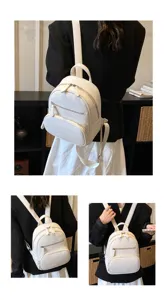 Casual white mini backpack for women, compact PU leather daypack with stylish front zipper pockets.