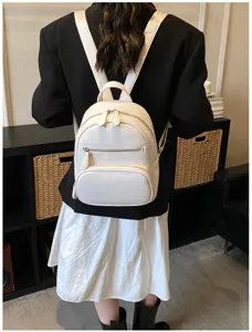 White PU leather mini backpack for women, casual daily daypack with zipper pockets and top handle.