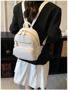 Detailed view of women casual white leather backpack with front zipper pocket and top handle.