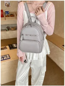 Grey leather mini backpack casual women daypack with front zipper pocket and top handle.
