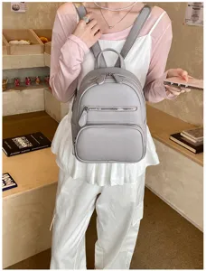 Casual grey leather mini backpack for women, stylish everyday daypack with front zip pocket.