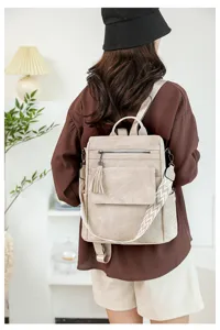 Vista dettagliata dello zaino casual da donna beige con ciondolo nappa alla moda e spallacci.