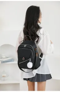 Zaino casual nero da donna con grazioso pompon soffice ideale per viaggi e scuola.