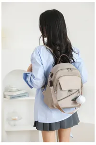 Vista dettagliata dello zaino casual da donna con tasche con zip e grazioso pompon.