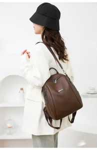 Detailed view of the dark brown leather commuter backpack, highlighting fine texture and hardware.