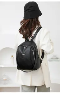 Detailed view of the women's black leather casual backpack showing quality texture and zippers.