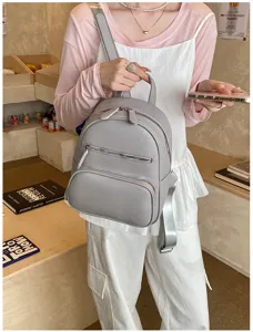 Grey mini backpack for women, casual leather daypack with front zip pocket for daily use.