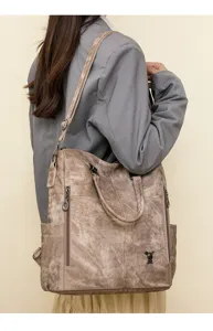 Detail view of multi-functional soft leather women's shoulder bag with multi-way strap design.