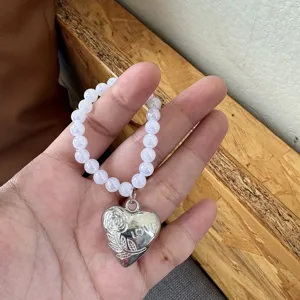 Weißer irisierender Perlenring mit Herzanhänger und eingravierter Rose sowie LOVE