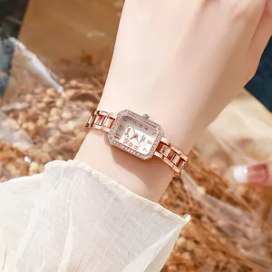 Primer plano de elegante reloj de cuarzo cuadrado en oro rosa con pedrería para mujer
