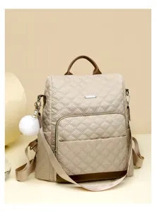 Sac à dos matelassé élégant pour femme avec pendentif duveteux, idéal pour le travail et voyage.
