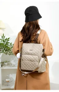 Sac à dos matelassé pour femme, sac de voyage élégant avec des détails bruns et bretelles.