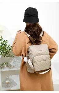 Sac à dos matelassé élégant pour femme, sac de voyage chic avec pendentif en peluche.