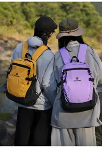 Vue détaillée en extérieur de deux sacs à dos colorblock portés, grande capacité utile.