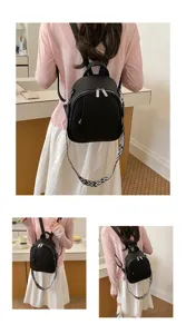 Vue détaillée d un sac à dos pour femme en cuir noir avec large bandoulière à motifs.
