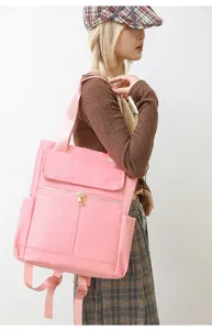 Vue détaillée du sac à dos rose élégant et polyvalent, montrant sa texture et ses fermetures.