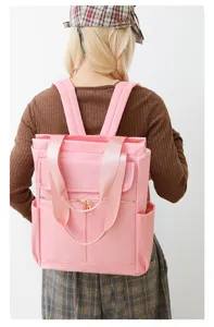 Vue détaillée du sac à dos décontracté rose pour femmes, élégant sac de voyage en tissu.