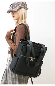 Vue détaillée du sac à dos noir en nylon mettant en valeur ses bretelles et fermetures.