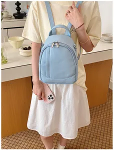 Gros plan du sac à dos pour femme en cuir souple bleu clair montrant fermetures et poche.