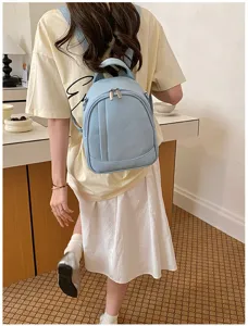 Vue detaillee du sac a dos pour femme en cuir souple bleu clair, avec coutures et fermetures.