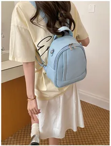 Mini sac à dos pour femme en cuir souple bleu clair avec poches zippées et bretelles.