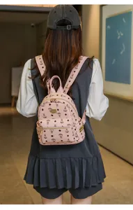 Gros plan détaillé d'un mini sac à dos en cuir rose avec motif d'ours et de losanges pour femmes.