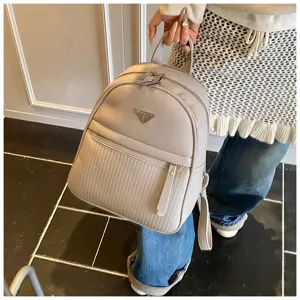 Detail view of stylish light grey PU leather backpack with front zipper pocket and metallic plate.