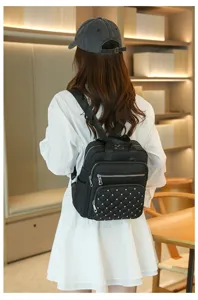 Detail shot of black fashion backpack with quilted diamond pattern and stylish metal studs.