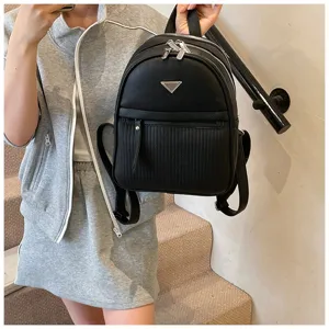 Women black PU leather casual backpack with trendy triangular metal plaque detail.