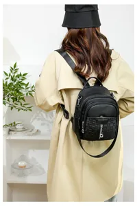 Detail view of the stylish black PU leather women backpack showcasing textured front pocket design.