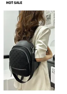 Women fashion black leather backpack detail view showing embossed pattern and front pocket.