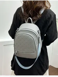 Women fashion backpack detail view, stylish light grey leather with embossed geometric pattern bag.
